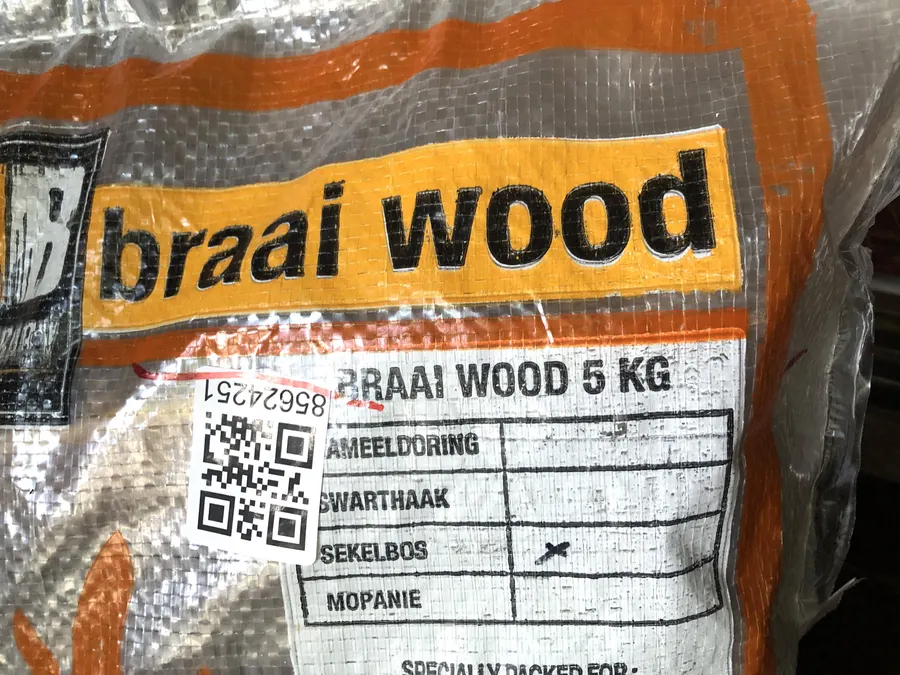 A retail bag of braai wood, labelled with the wood types it contains
