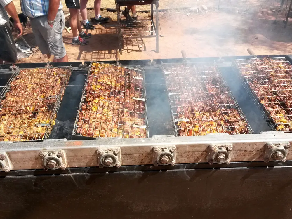 Sosaties skewers over an open fire on a simple grid