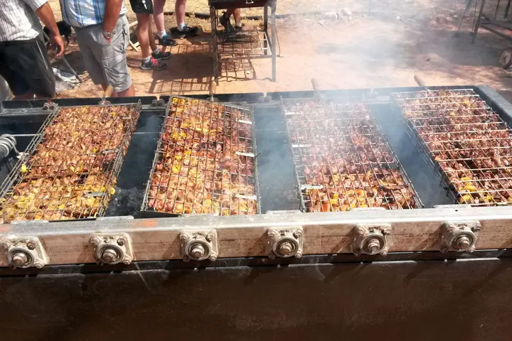Sosaties skewers over an open fire on a simple grid